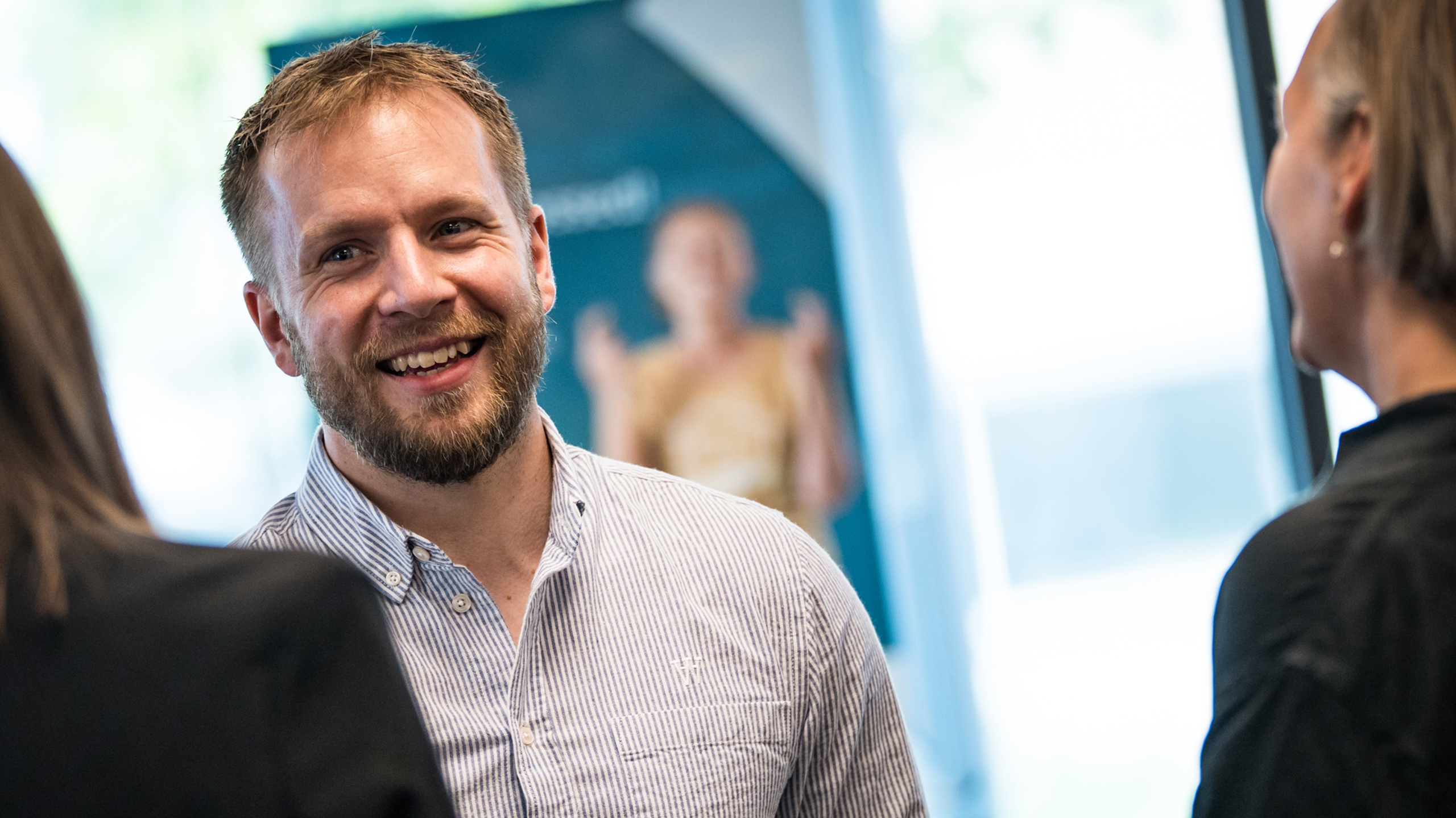 Smilende rådgiver taler med kunde.