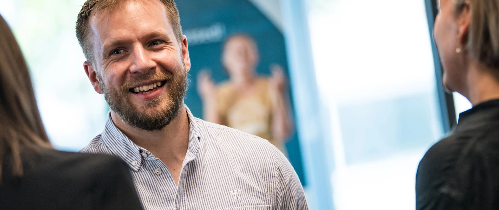 Smilende rådgiver taler med kunde.