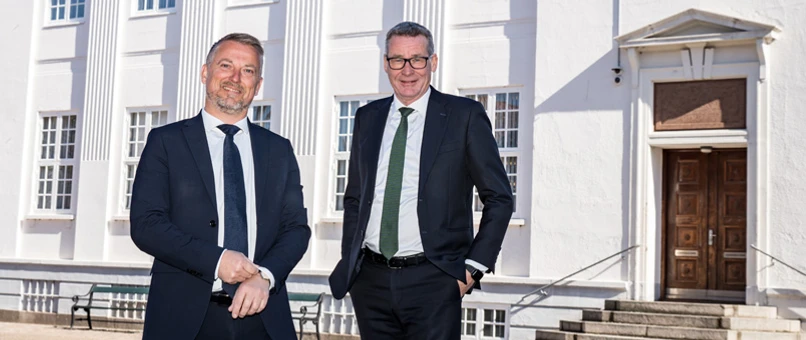 Sigurd Linde Simmelsgaard står sammen med tidligere bankdirektør Lars Møller Kristensen foran bankens hovedsæde i Grenaa.
