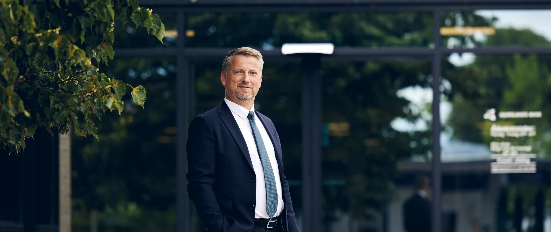 Sigurd Bohlbro Simmelsgaard, Adm. Direktør, CEO i Djurslands Bank foran Djurslands Bank filial i Grenaa.