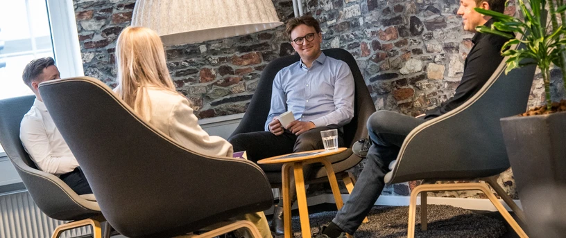Aktiv kunderådgivning. To kunder og to rådgivere sidder og taler sammen.