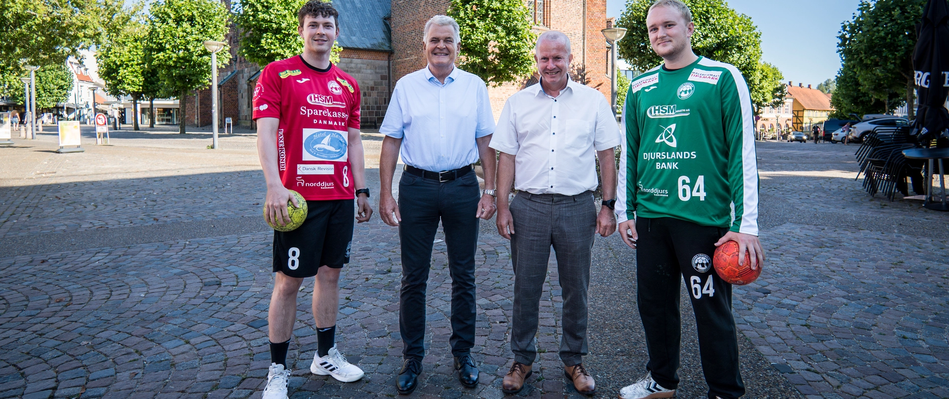 To håndboldspillere fra Norddjurs Håndbold står samme med områdedirektør Peter Møller fra Djurslands Bank og direktør Peter Lading Sørensen fra Sparekassen Danmark