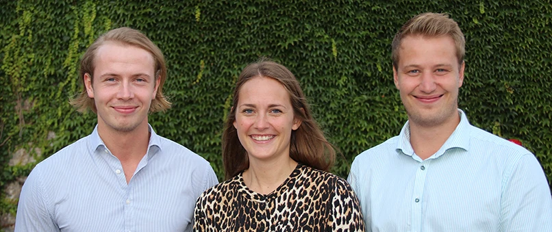 Tre unge finansøkonompraktikanter. En ung kvinde og to unge mænd.
