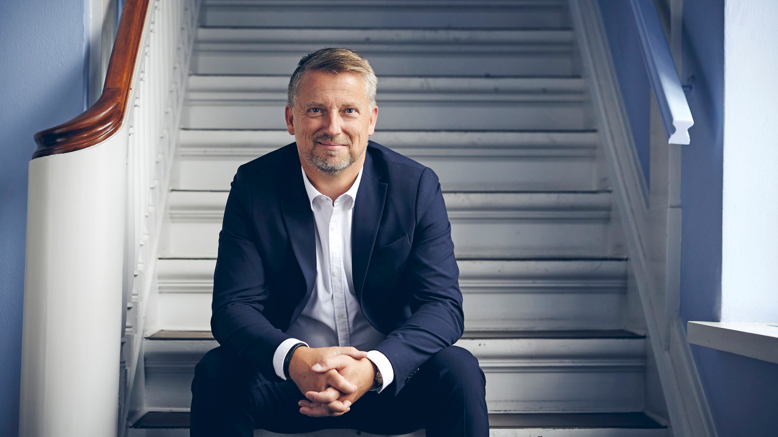 Sigurd Bohlbro Simmelsgaard, Adm. Direktør, CEO i Djurslands Bank siddende på en trappe