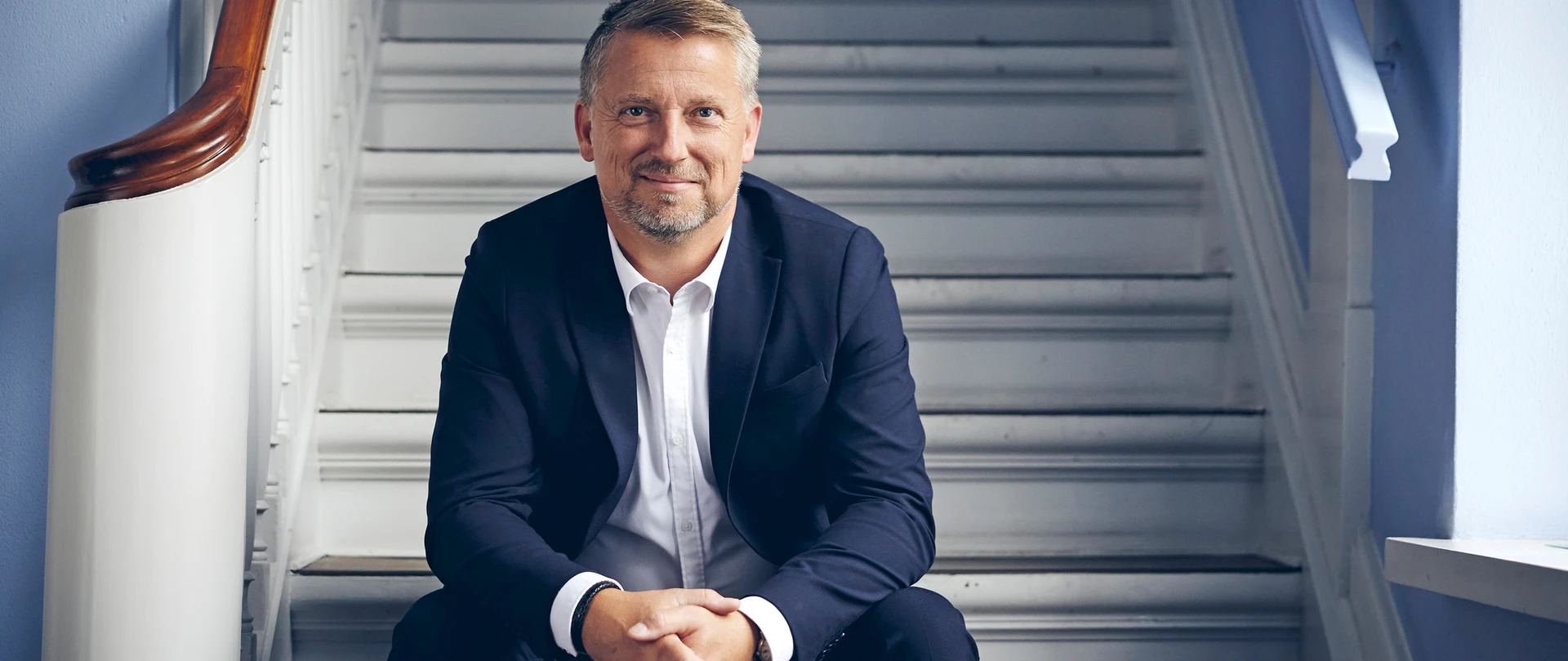 Sigurd Bohlbro Simmelsgaard, Adm. Direktør, CEO i Djurslands Bank siddende på en trappe