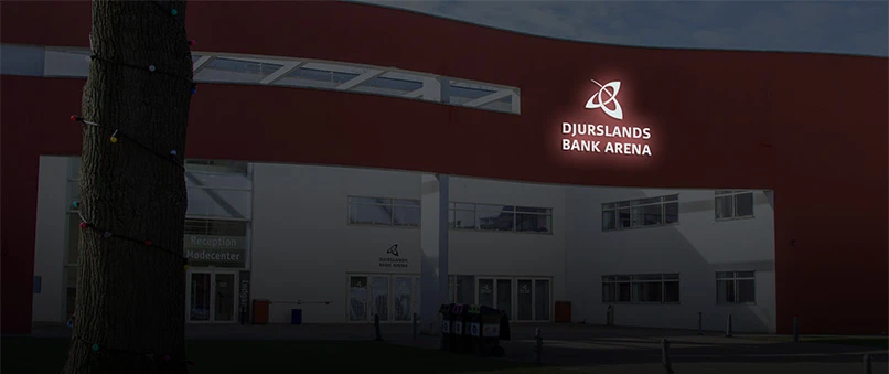 Djurslands Bank Arena i Aarhus med Djurslands Bank loget lysende i mørket.